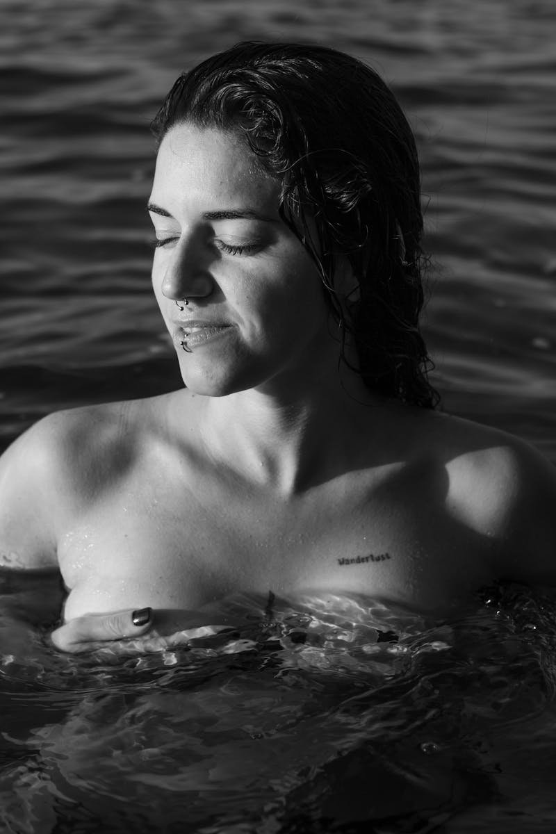 Tranquil black and white portrait of a woman in water, capturing serene beauty.